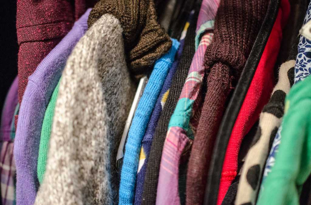 Colourful clothes hanging in a closet, a reminder to shop your own wardrobe first