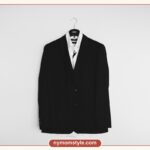 Black blazer on a hanger against a plain white wall, a minimalist wardrobe essential